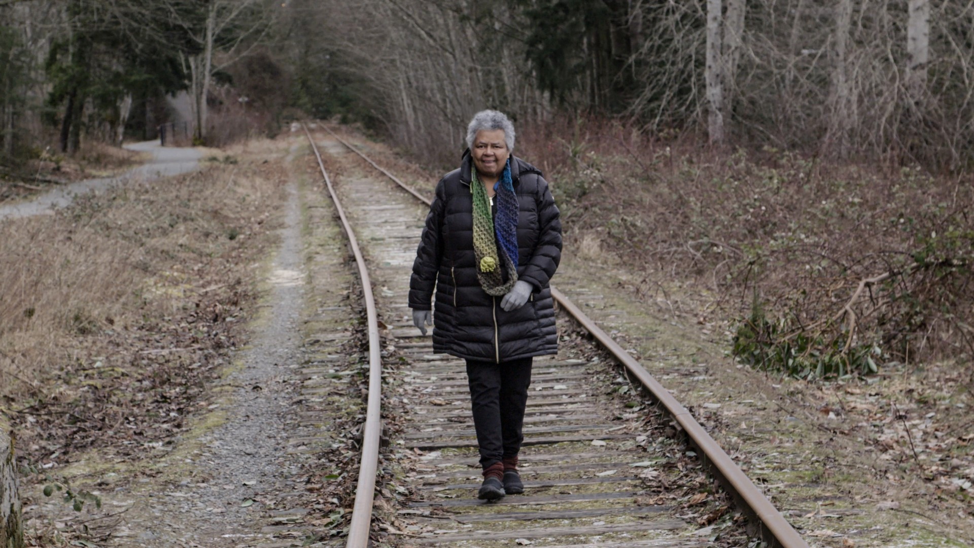 Woman walking on train tracks